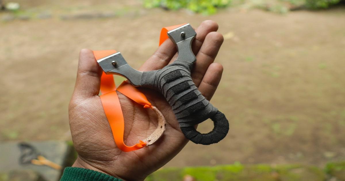 orange prepper slingshot band in a hand