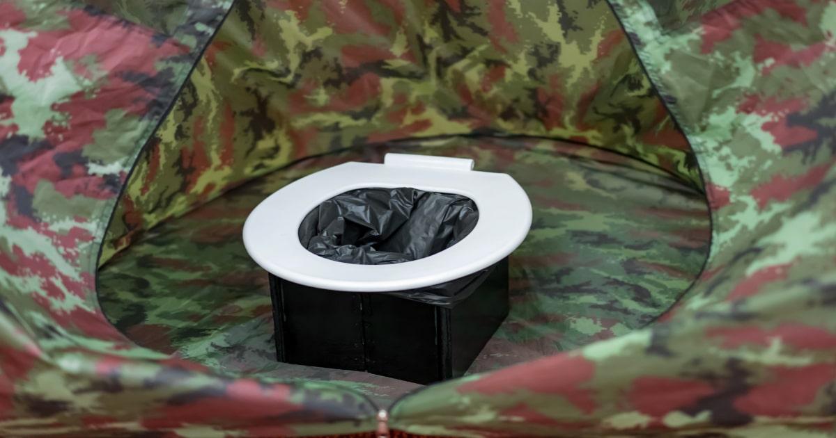 portable camping toilet in camouflage tent to deal with human waste