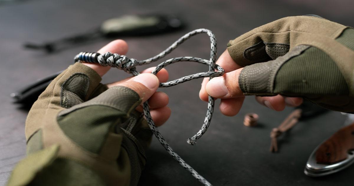 prepper tying knots with a piece of paracord
