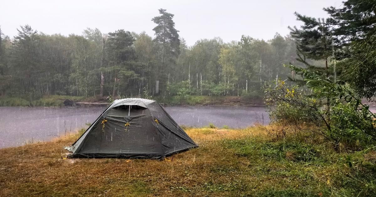 tent in heavy rainstorm by river